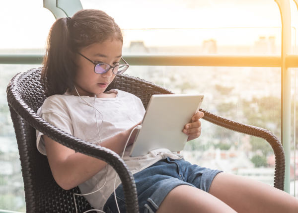  a girl with glasses reading on her ipad